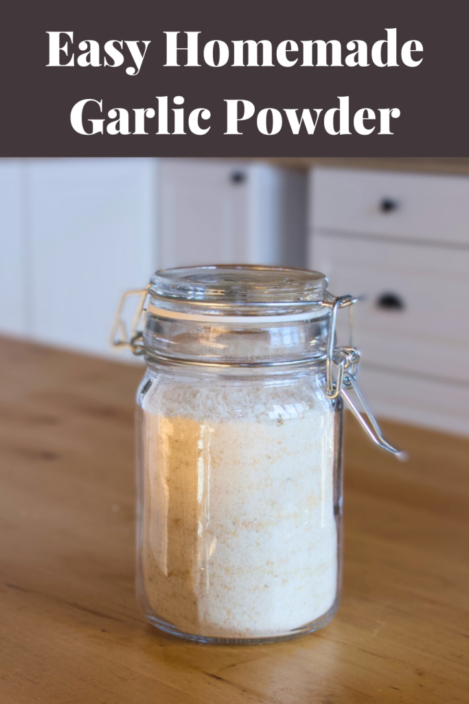 Glass jar filled with garlic powder on a wooden counter