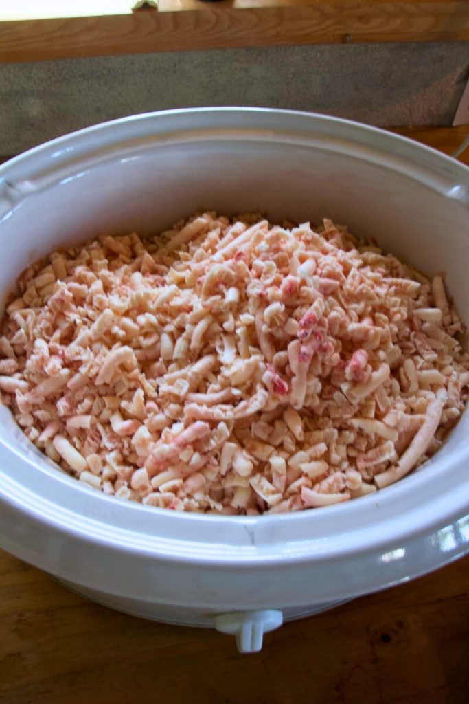 ground up beef suet pieces in a slow cooker on the counter