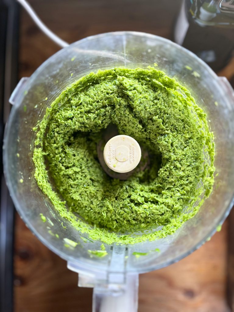 chopped garlic scapes in a food processor bowl