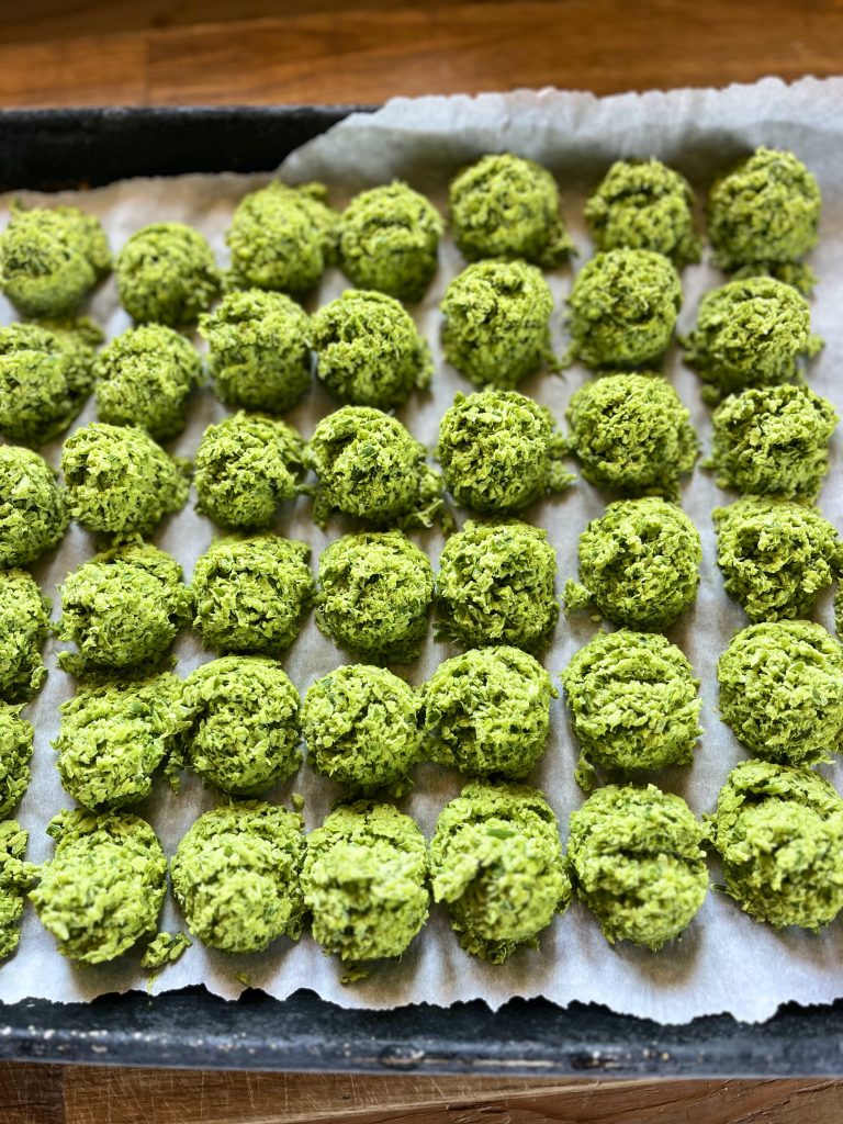 scoops of frozen garlic scapes on a baking tray