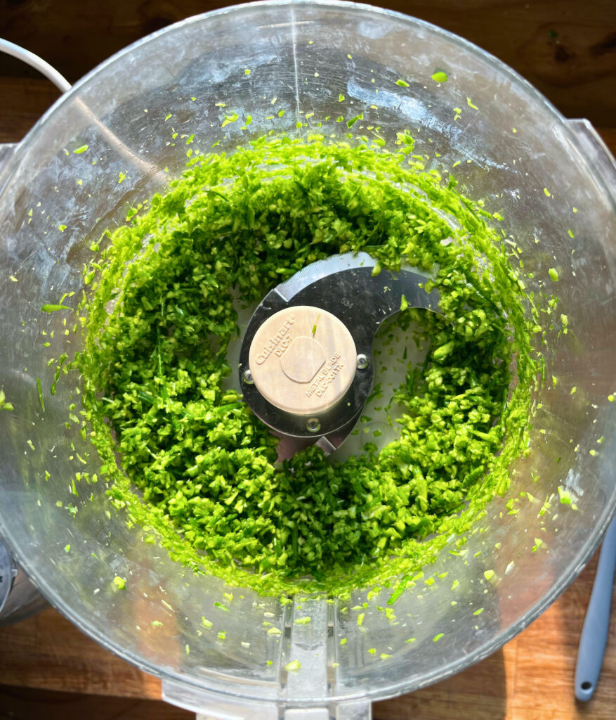 roughly chopped garlic scapes in a food processor