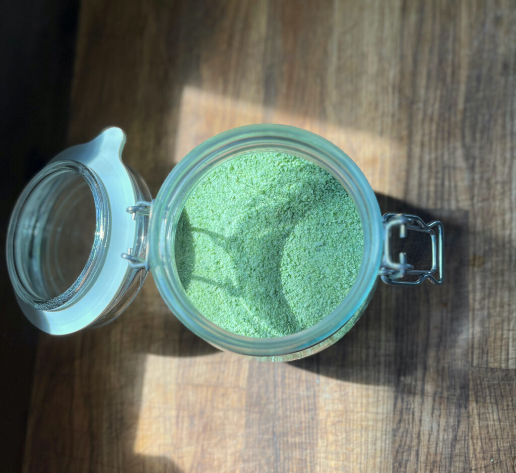 garlic scape sea salt in a glass jar on a wooden board